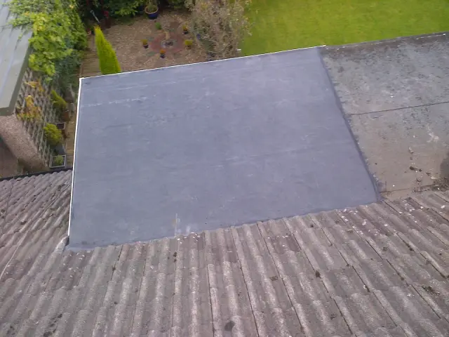 Finished black EPDM rubber membrane installation on a flat residential roof section