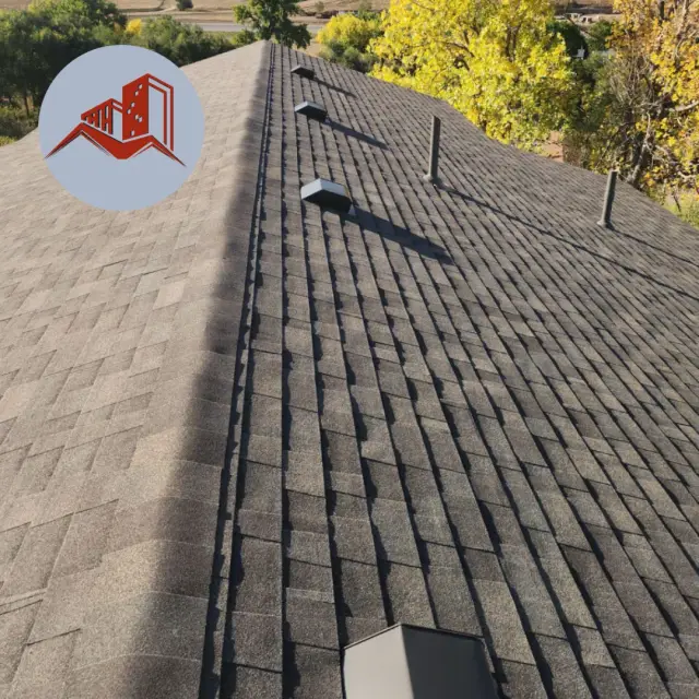 Aerial view of a gray architectural asphalt shingle roof with a roof vent on a suburban home