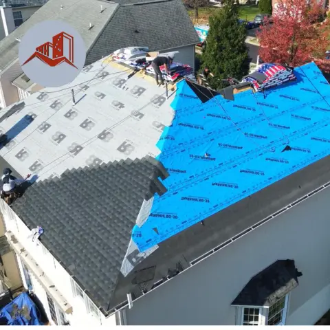 Aerial view of a residential roof replacement in progress with synthetic underlayment and bundles of new shingles staged