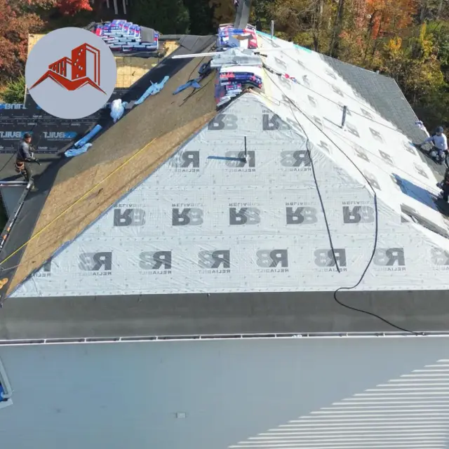 Aerial of a steep-pitch roof during replacement with exposed plywood decking on one side and synthetic underlayment on the other
