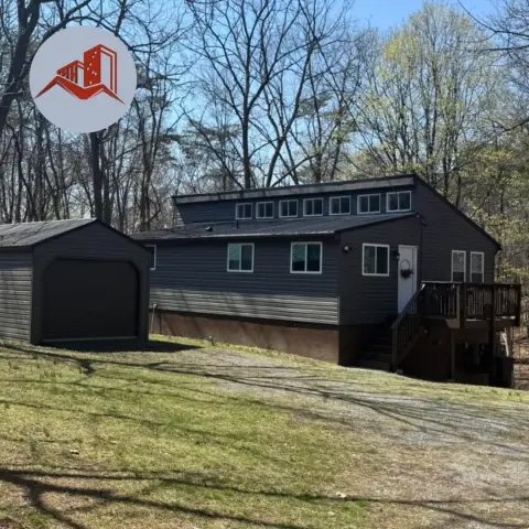 Aerial view of a finished dark charcoal standing seam metal roof on a residential home
