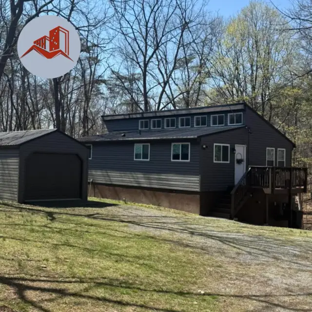 Aerial view of a finished dark charcoal standing seam metal roof on a two-story dark gray residential home