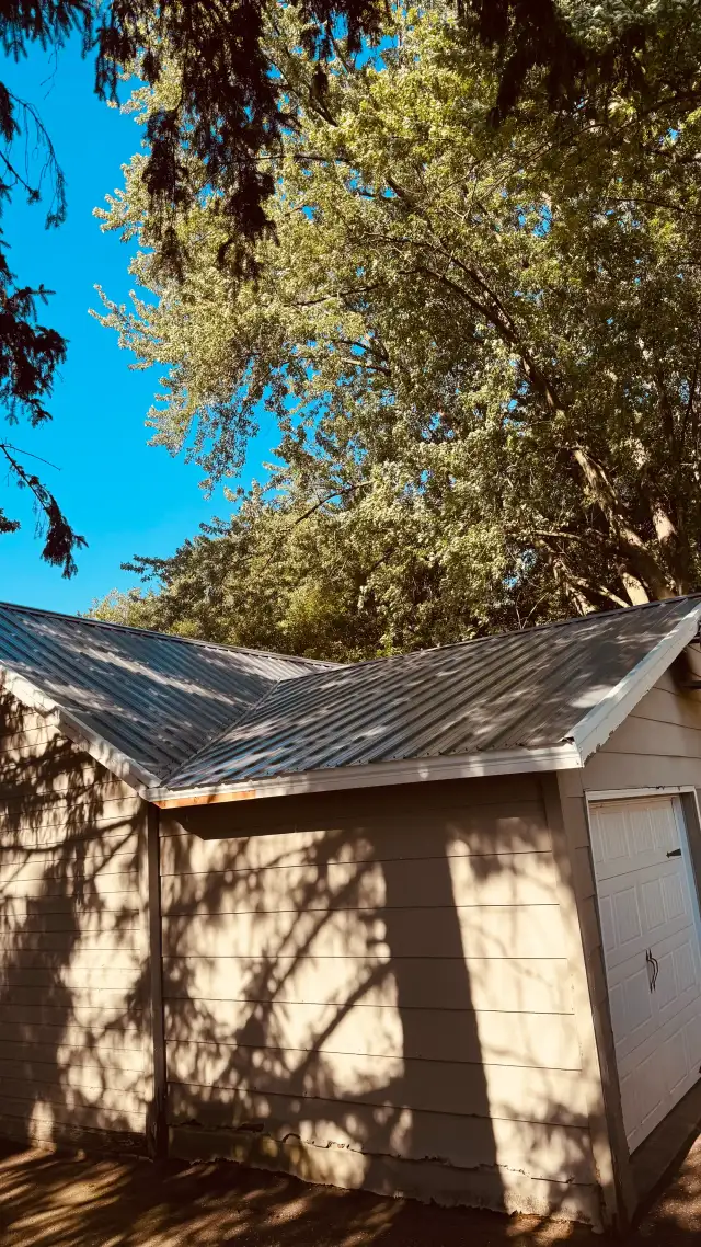 New ribbed metal roof valley over a garage, viewed from the ground