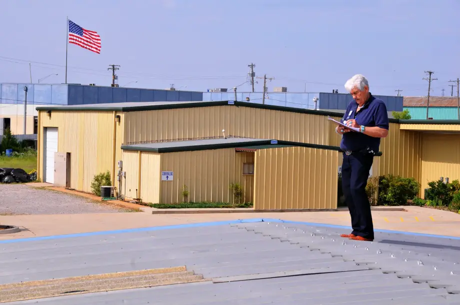 Inspector photographing hail-damaged asphalt shingle roof for storm damage claim documentation